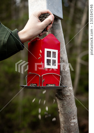 The red, swedish cottage shaped bird feeder. 130384546