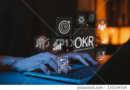 OKR Objectives and Key Results Strategy Planning Concept. Person using laptop with OKRs icon representing target, goals, performance metrics, business growth, achievement tracking, achieving corporate 130384584