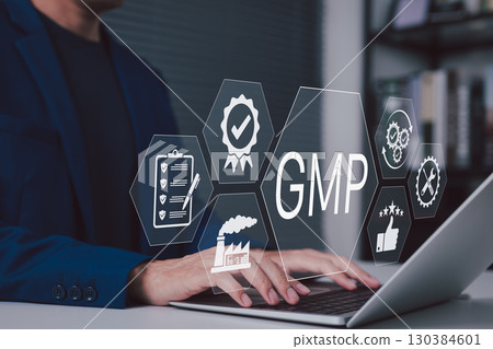 GMP compliance and quality assurance in manufacturing. Businessman working on laptop with icons represent GMP compliance, quality control, certification, manufacturing standards in corporate setting, 130384601