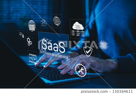 SaaS Software as a Service Digital Cloud Technology. Hands typing on laptop with SaaS icons representing cloud computing, data storage, software integration, security, and service based applications. 130384611
