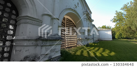 light shines through the old wooden gates of the monastery on the grass light shines through the old wooden gates of the monastery on the grass 130384648