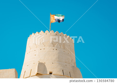 Stone arabic watchtower with waving United Arab Emirates National Flag in Al Jazirah Al Hamra haunted town in Ras Al Khaimah. High quality photo Stone arabic watchtower with waving United Arab Emirates National Flag in Al Jazirah Al Hamra haunted town in Ras Al Khaimah. High quality photo 130384780