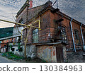 A brick building with a yellow pipe on top of it. 130384963