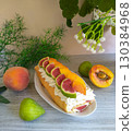 A fruit cake with figs and oranges on top of a white plate. 130384968
