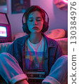 Teenager enjoying music with headphones and portable cassette player in a room illuminated by neon lights, creating a nostalgic and retro atmosphere 130384976