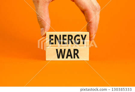 Energy war symbol. Concept words Energy war on beautiful wooden block. Beautiful orange table orange background. Businessman hand. Business and Energy war concept. Copy space. Energy war symbol. Concept words Energy war on beautiful wooden block. Beautiful orange table orange background. Businessman hand. Business and Energy war concept. Copy space. 130385333