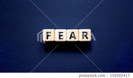 Fear symbol. Concept word Fear on beautiful wooden blocks. Beautiful black table black background. Business, lifestyle and fear concept. Copy space. 130385417
