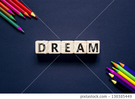 Dream symbol. Concept word Dream on beautiful wooden blocks. Beautiful black table black background. Beautiful colored pencils. Business lifestyle dream concept. Copy space. 130385449