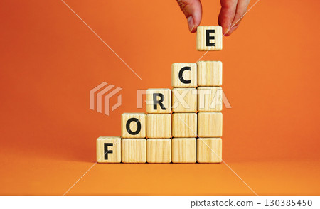 Force symbol. Concept word Force on beautiful wooden blocks. Beautiful orange table orange background. Businessman hand. Business lifestyle force concept. Copy space. 130385450