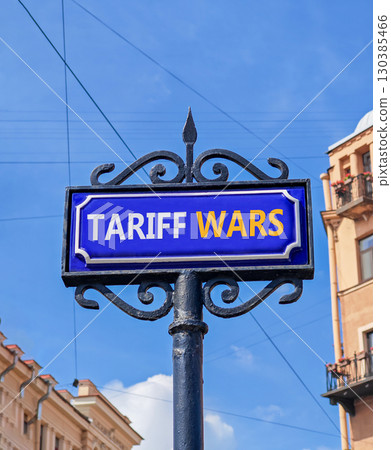 Trade tariff wars symbol. Concept word Tariff wars on beautiful blue road sign. Beautiful blue sky and buildings background. Business trade tariff wars concept. Copy space. Trade tariff wars symbol. Concept word Tariff wars on beautiful blue road sign. Beautiful blue sky and buildings background. Business trade tariff wars concept. Copy space. 130385466