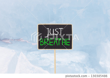 Just breathe and psychological symbol. Concept words Just breathe on beautiful yellow black blackboard. Beautiful blue ice background. Business psychological and Just breathe concept. Copy space Just breathe and psychological symbol. Concept words Just breathe on beautiful yellow black blackboard. Beautiful blue ice background. Business psychological and Just breathe concept. Copy space 130385486
