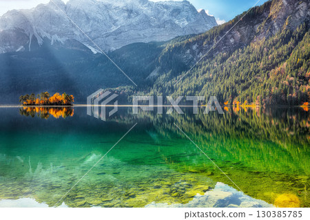 Amazing autumn landscape of Eibsee Lake in front of Zugspitze summit under sunlight. Amazing autumn landscape of Eibsee Lake in front of Zugspitze summit under sunlight. 130385785
