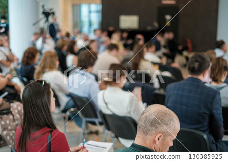 Audience in a conference room focusing during a professional presentation 130385925