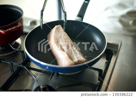 Grilling a block of pork in a frying pan to make char siu 130386222