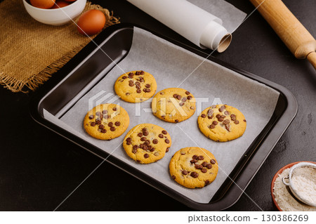 Golden brown chocolate chip cookies cooling on tray, perfect homemade sweet snack 130386269