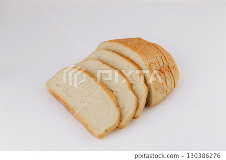 Freshly sliced white bread loaf on white background, perfect for bakery or food ads 130386276