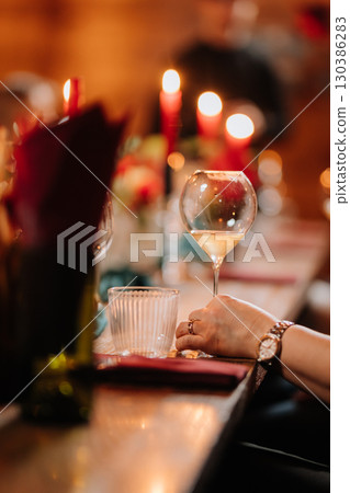 Elegant dinner party table setting with candles, wine and cozy atmosphere 130386283
