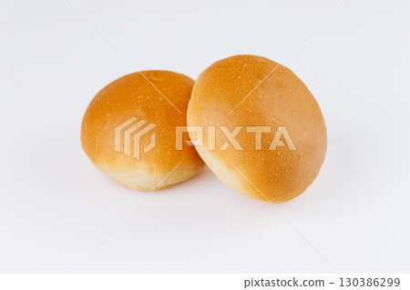 Two fresh golden hamburger buns on white background, ideal for bakery or food packaging design 130386299