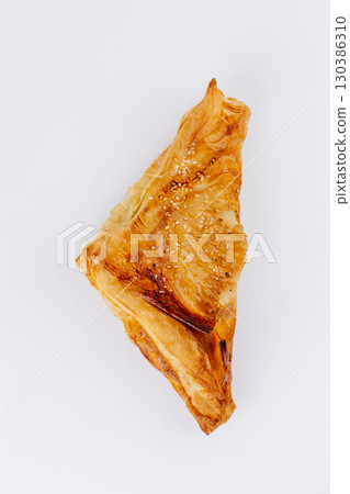 Golden puff pastry triangles with sesame seeds isolated on white background Golden puff pastry triangles with sesame seeds isolated on white background 130386310