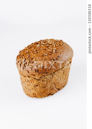 Whole grain bread loaf with sunflower seeds on white background, healthy bakery product 130386316