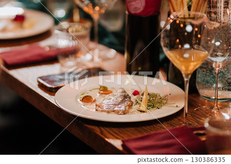 Gourmet fish fillet served with creamy sauce and microgreens on elegant dinner table Gourmet fish fillet served with creamy sauce and microgreens on elegant dinner table 130386335