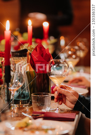 Elegant dinner scene with wine and candles on a festive decorated table 130386337
