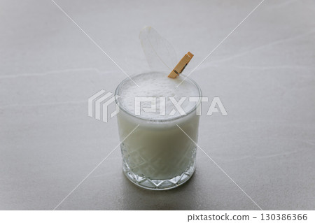 Minimalist white creamy cocktail with airy foam and modern decorative touch on grey background 130386366