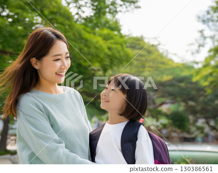 微笑的母親和女兒在公園玩耍 微笑的母親和女兒在公園玩耍 130386561
