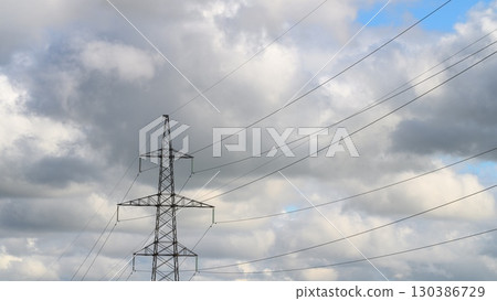 Power Lines Stretching Beneath a Dramatic Cloudy Sky with Flocking Birds Flying Around Power Lines Stretching Beneath a Dramatic Cloudy Sky with Flocking Birds Flying Around 130386729