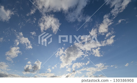 A Beautiful Sky Filled with Fluffy Clouds and Rays of Sunlight Bringing Warmth and Joy 130386908