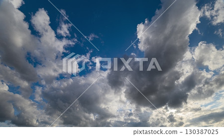 A Beautiful Dynamic Sky Filled with Fluffy White Clouds During a Bright Afternoon 130387025