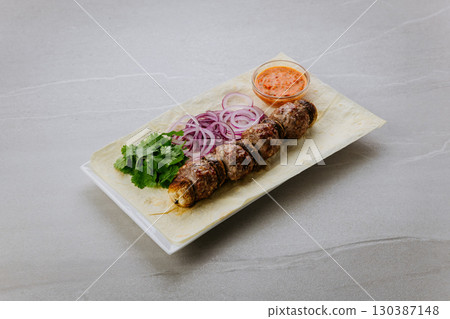 Grilled meat and mushrooms on lavash with onion, cilantro and spicy red pepper sauce Grilled meat and mushrooms on lavash with onion, cilantro and spicy red pepper sauce 130387148
