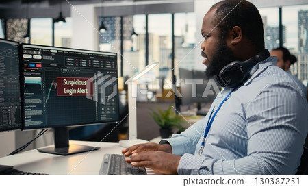 Stressed trader at work investigating suspicious access on trading account after system triggers warning. Broker worried about security popup on PC about attempted breach of client account 130387251