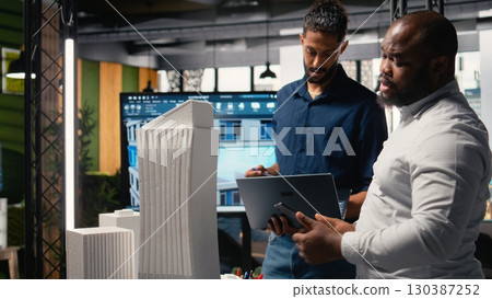 Contractors and property developers work together on a city planning initiative aimed at infrastructure and housing growth through investment and design. Architectural 3D models. 130387252
