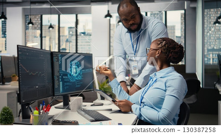 Prop firm staff members using artificial intelligence tech to ensure smooth trading operations. Team of traders in office using AI chatbot to analyze stock market portfolio positions 130387258