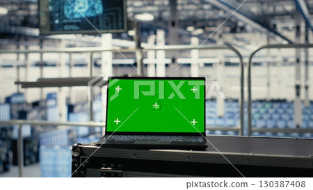 Green screen laptop in server hub with hardware supporting AI driven services. Mockup notebook in data center storing and processing vast datasets for artificial intelligence operations 130387408