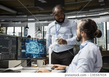 Brokerage team leader and specialist leverage AI to optimize trading strategies. Manager supervising trader in office using deep learning to enhance predictive accuracy of stock exchange movements Brokerage team leader and specialist leverage AI to optimize trading strategies. Manager supervising trader in office using deep learning to enhance predictive accuracy of stock exchange movements 130387434