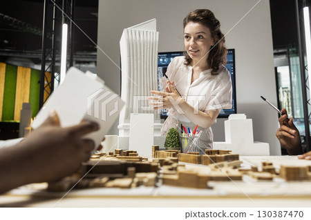 Property developer leads the planning session with 3D models for details and zoning regulations, focusing on site development and infrastructure growth for housing and urban development. 130387470