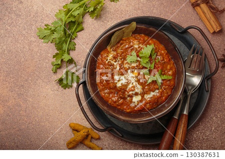 Dal makhani with cream and coriander in bowl is served with spices top view, traditional dish of India Dal makhani with cream and coriander in bowl is served with spices top view, traditional dish of India 130387631