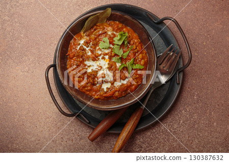 Dal makhani with cream and coriander in bowl is served with spices top view, traditional dish of India 130387632