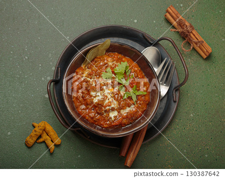 Dal makhani with cream and coriander in bowl is served with spices, traditional dish of India Dal makhani with cream and coriander in bowl is served with spices, traditional dish of India 130387642
