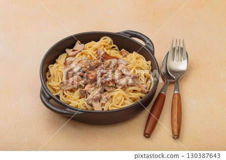 Creamy chanterelle mushroom pasta in cast iron pan with fork and spoon Creamy chanterelle mushroom pasta in cast iron pan with fork and spoon 130387643