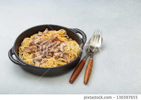 Creamy chanterelle mushroom pasta in cast iron pan with fork and spoon, space for text Creamy chanterelle mushroom pasta in cast iron pan with fork and spoon, space for text 130387655