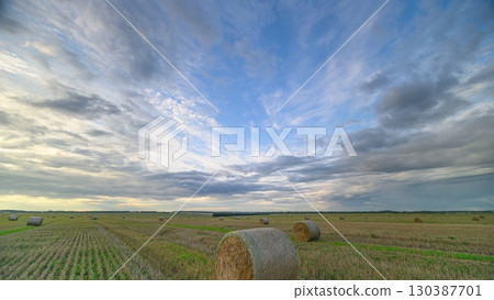 Stunning Autumn Fields with Hay Bales Set Against Dramatic and Expansive Skies Above Stunning Autumn Fields with Hay Bales Set Against Dramatic and Expansive Skies Above 130387701