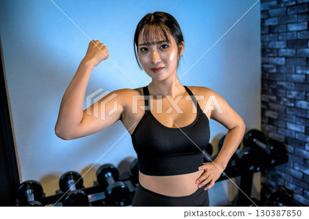 Woman flexing her bicep, cool woman exercising at the gym, upper body, muscle training girl Woman flexing her bicep, cool woman exercising at the gym, upper body, muscle training girl 130387850
