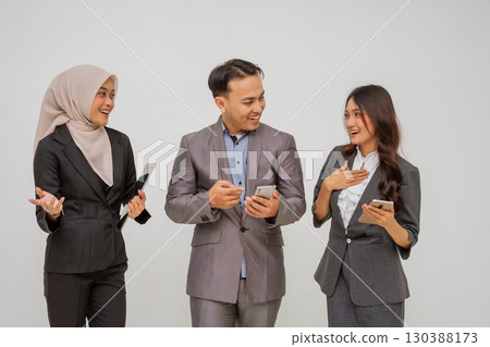 Professional Team Engaging with Mobile Devices in Modern Office Environment Professional Team Engaging with Mobile Devices in Modern Office Environment 130388173