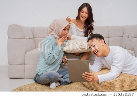 Friends are having fun together on a couch with a tablet, creating memories Friends are having fun together on a couch with a tablet, creating memories 130388197