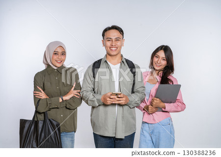 A Diverse Group of Students Smiling Joyfully with Their Gadgets in a Studio Setting 130388236