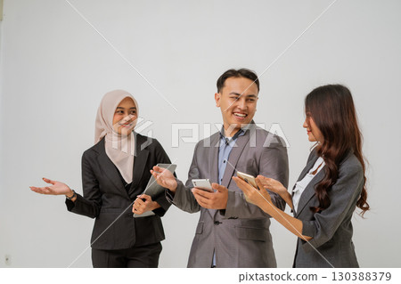 A Diverse Business Team Engaged in Discussion While Using Their Mobile Devices A Diverse Business Team Engaged in Discussion While Using Their Mobile Devices 130388379