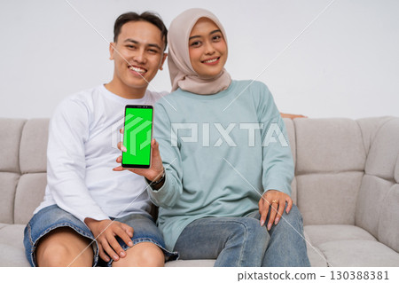 A couple enjoys time together sharing moments on a smartphone while relaxing A couple enjoys time together sharing moments on a smartphone while relaxing 130388381